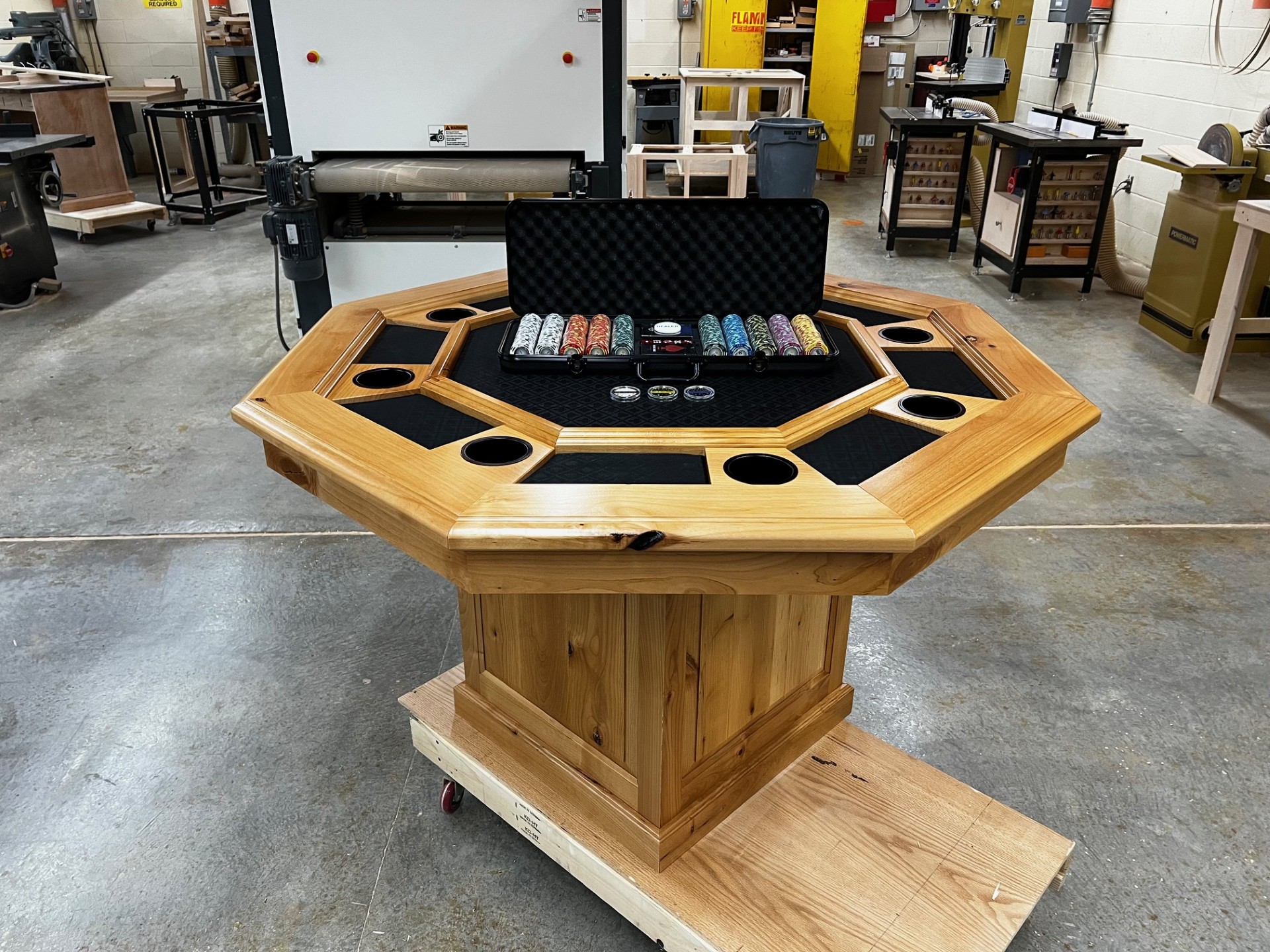 Poker Table A poker table with a case of poker chips on top of it sitting in a workshop