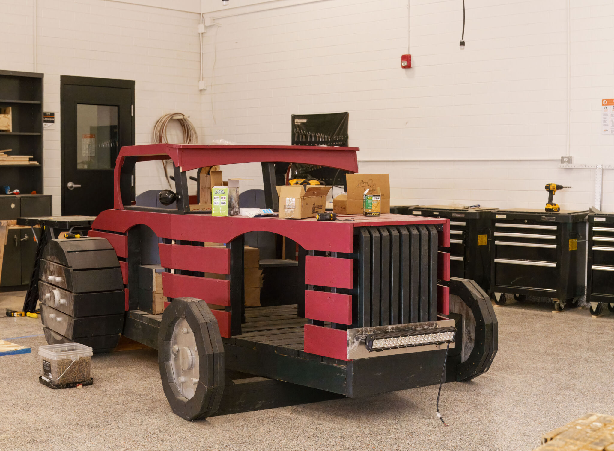 Hot Rod Playhouse A playhouse shaped like a vintage hotrod sitting in a workshop.