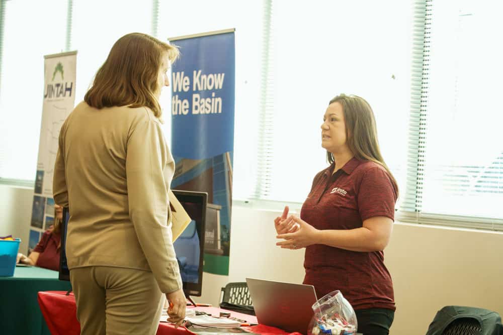 An adult female community member talking to an adult female about their company