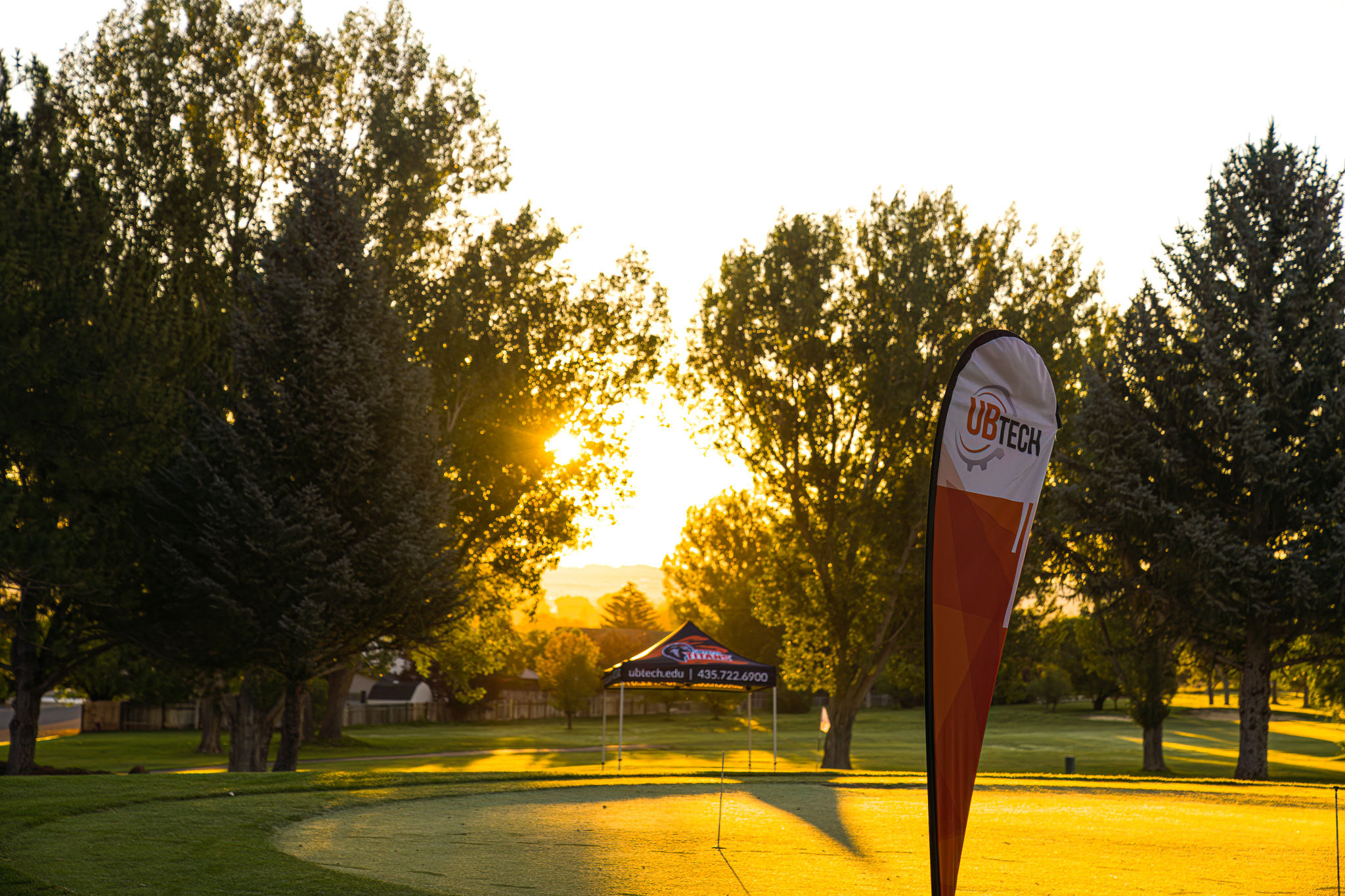 UBTech feather flag in front of a sunrise.