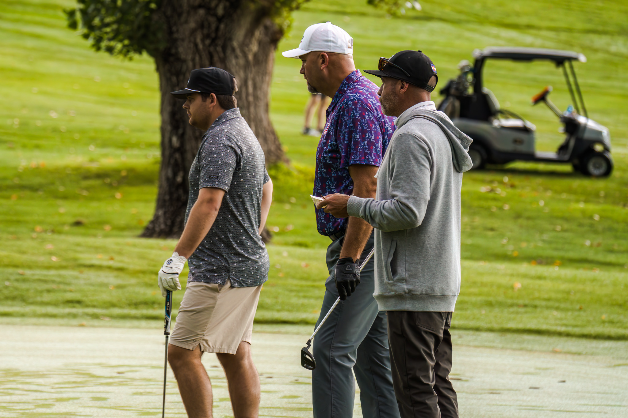 Three men watching a putt