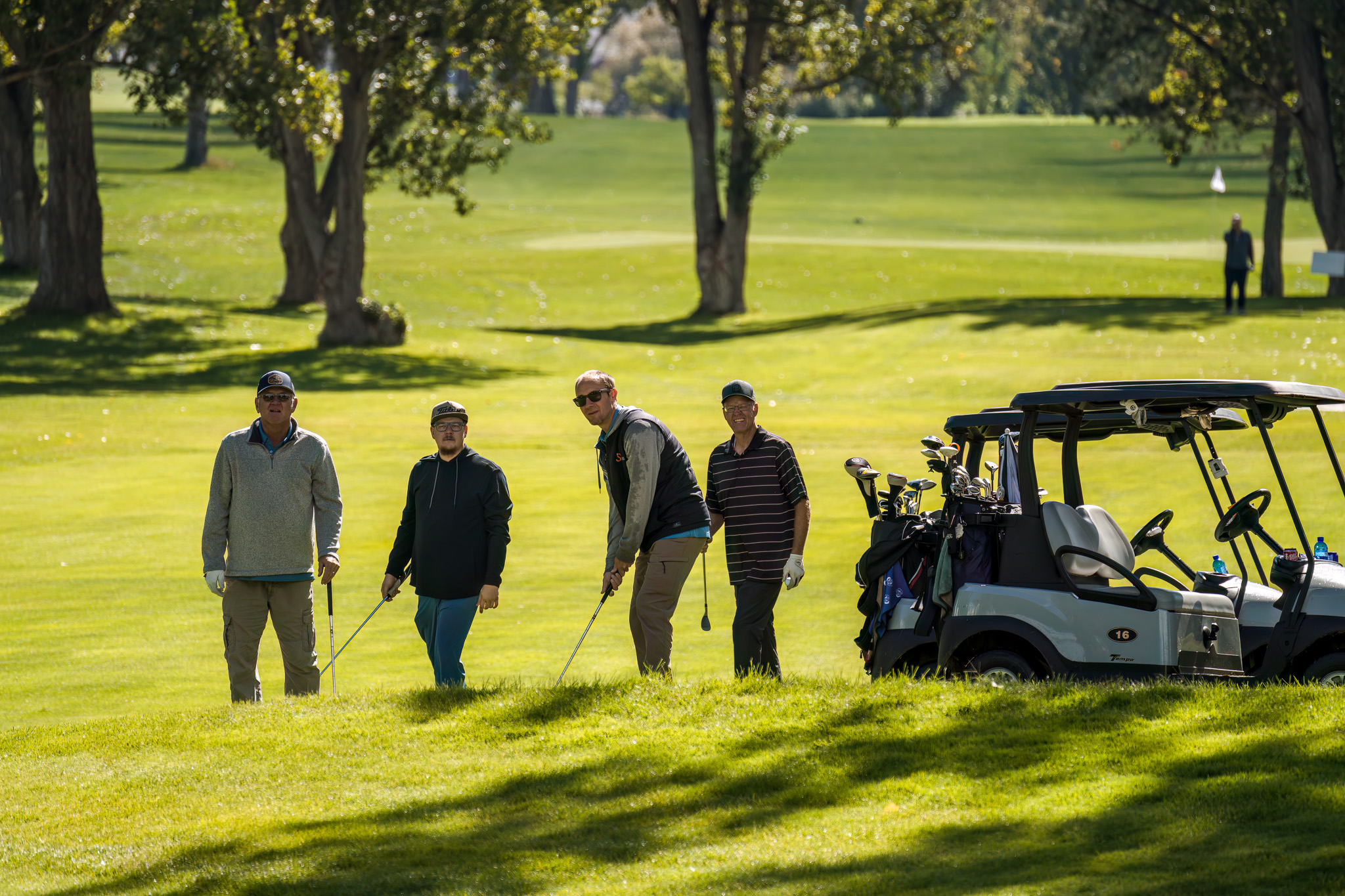 four men watching a ball from a chip