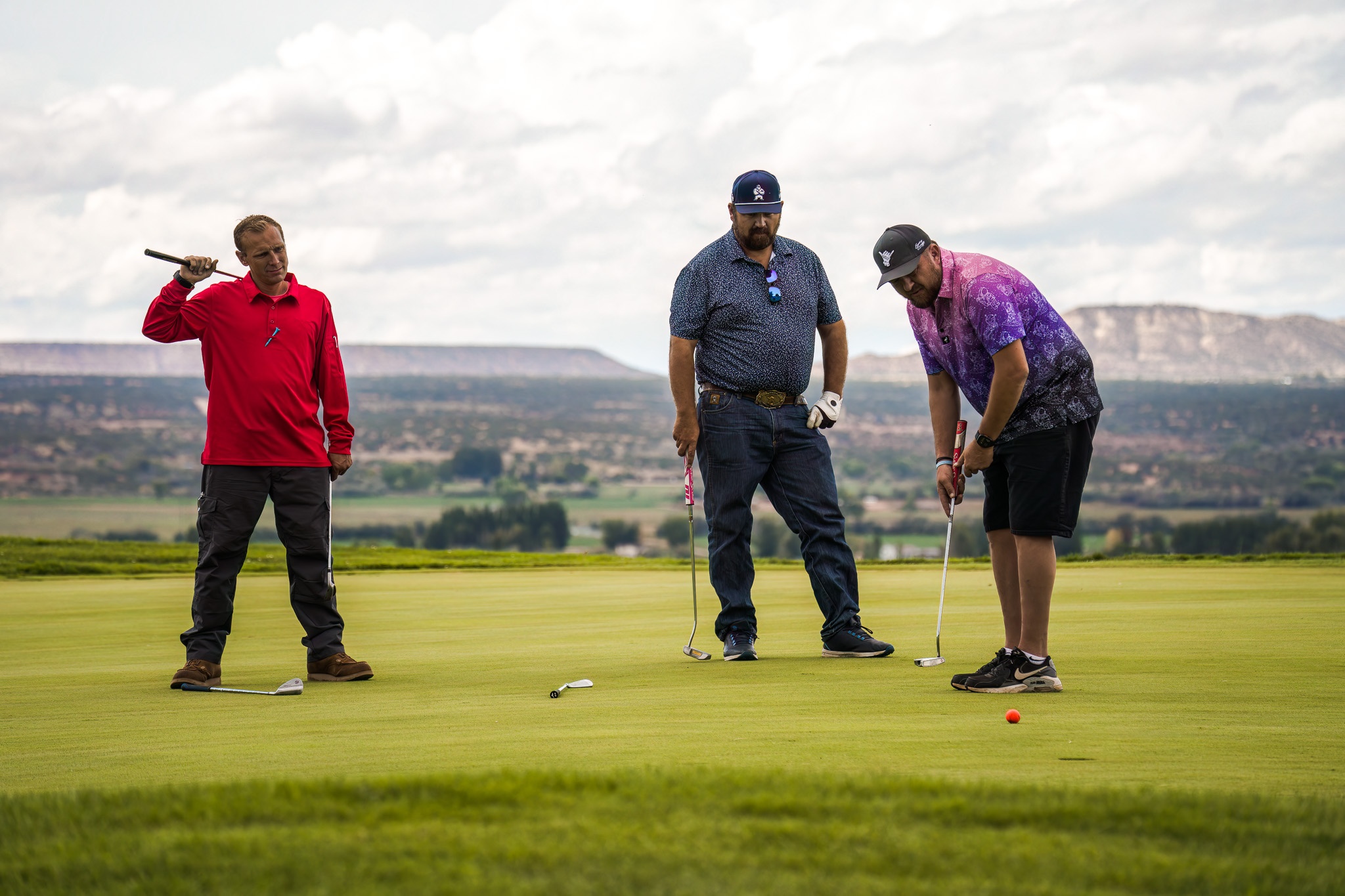 Three men watching a putt