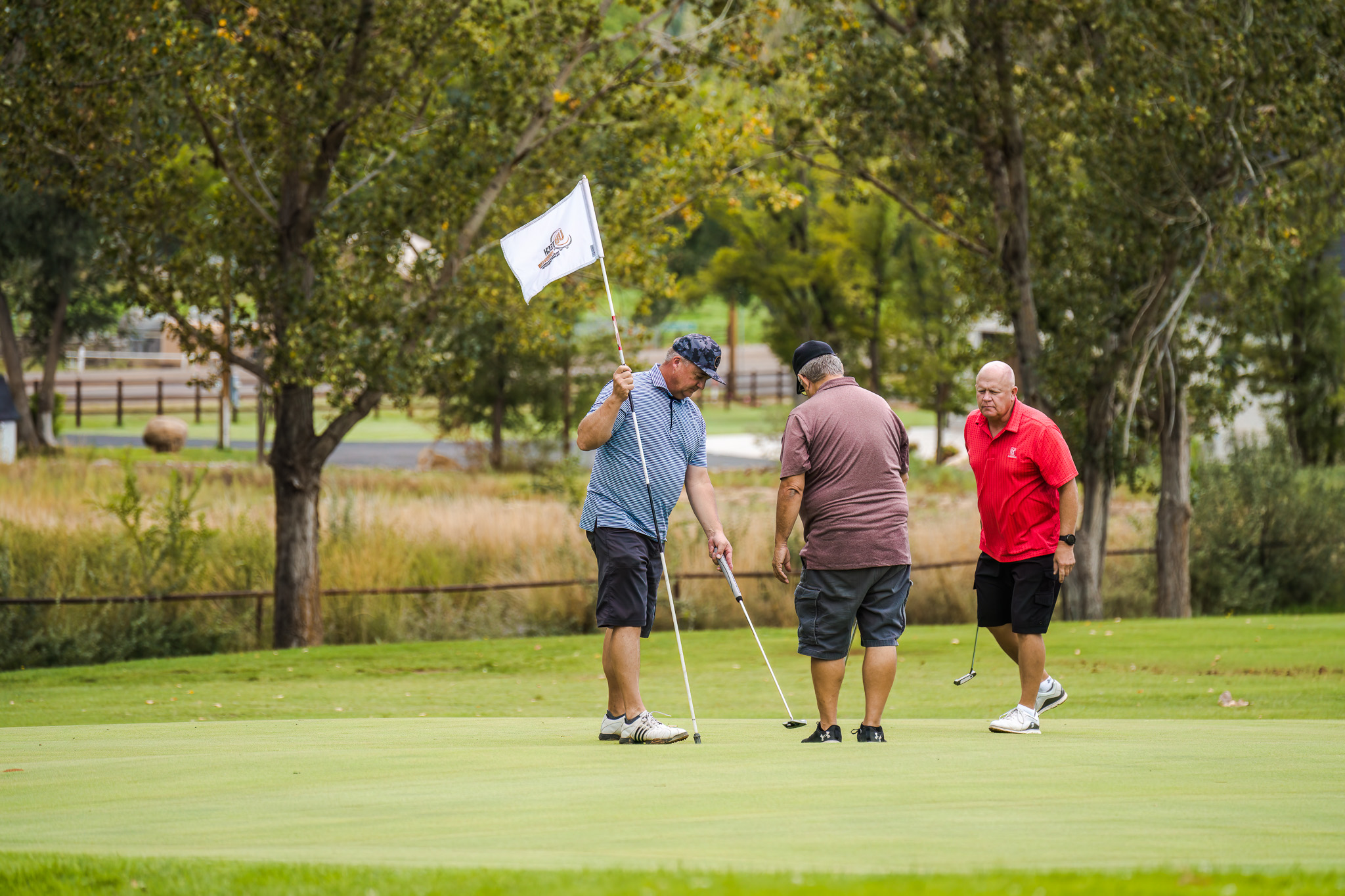 Three men watching a putt