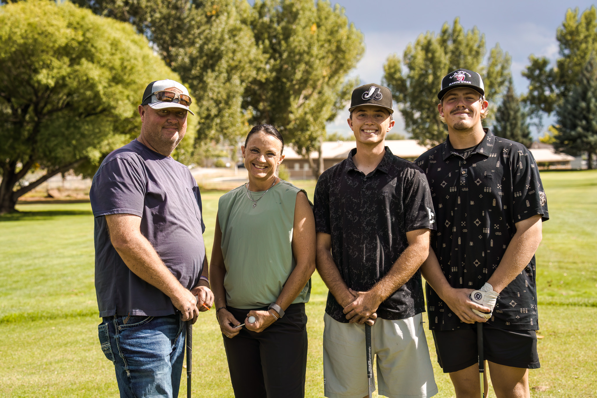 Three men and a women stand posing for a group photo